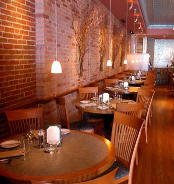 Interior photo of tables and a red brick wall.